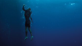 A person underwater wearing a PSI vest.