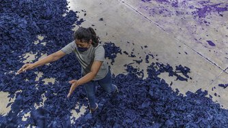 A women sorting fabric scraps.