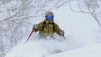 A kid takes powder turns in a storm.